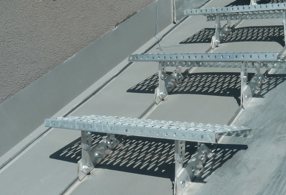 Strešné lávky pripevnené na plechovej falcovanej krytine, vytvárajúce schody.